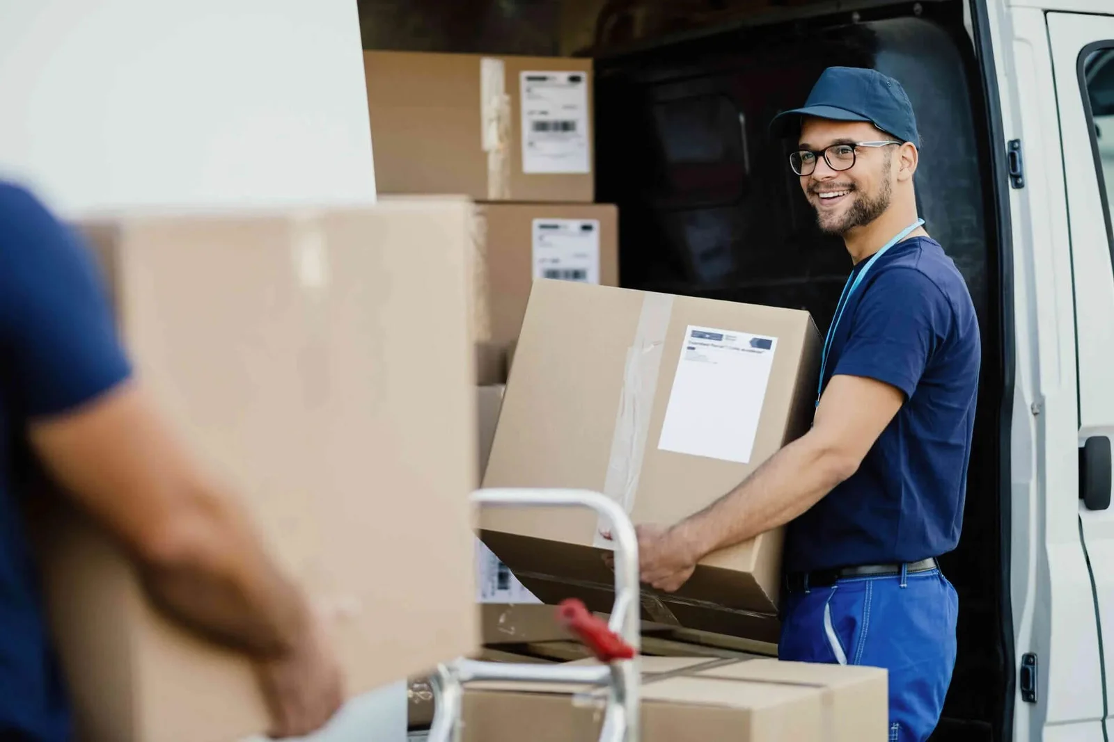 Affordable Movers crew member loading a labelled carton into the back of a moving van